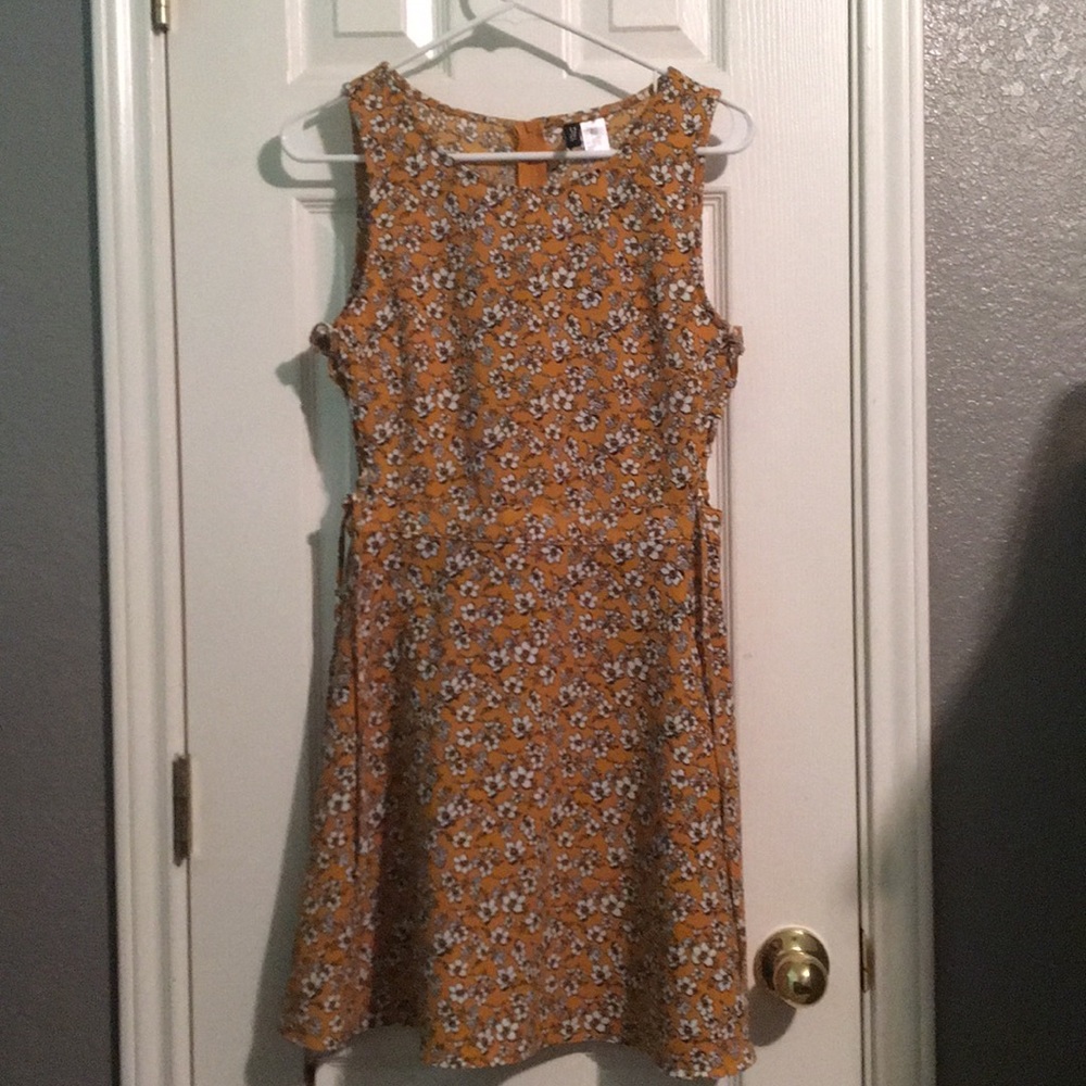 A mustard dress with flowers and cutouts.